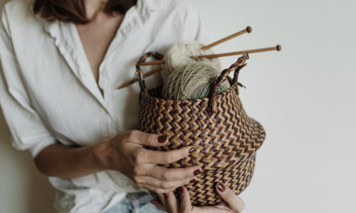Mulher segurando cesta com materiais para patchwork