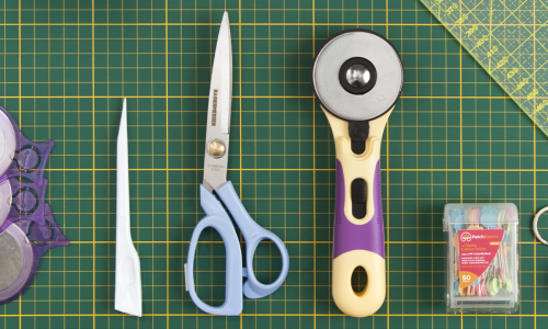 Imagem ilustrativa de ferramentas essenciais para costura: tesoura, cortador circular, régua, fita métrica e fita métrica.