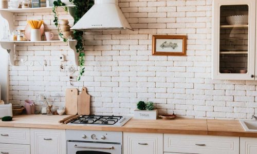Uma foto que mostra uma bancada de cozinha com alguns objetos sobre ela e um fogão próximo