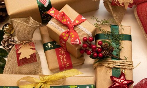 mesa com presentes natalinos, caixas e sacolas de presente, decoração natalina